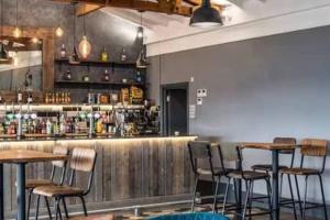 a bar with tables and chairs in a restaurant at Coastal Escape Bude Resort in Bude