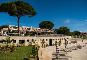 a building with a lot of chairs and a tree at Vila Bicuda Resort in Cascais