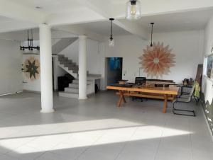 a large room with a wooden table and a staircase at Mi casa de campo Tlayacapan in Tlayacapan
