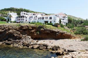 a group of white houses on a hill next to the water at Comitas Tramontana Park in Fornells