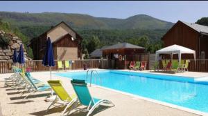 a large swimming pool with chairs and umbrellas at location Ax les Thermes in Ax-les-Thermes