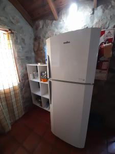 a white refrigerator in a room with a window at Cabañas Wasirumi Pileta y bajada al Rio in Bialet Massé