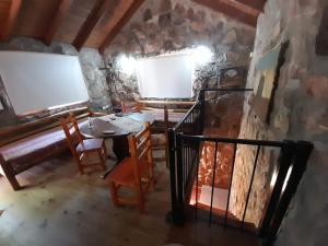 a dining room with a table and chairs and a stone wall at Cabañas Wasirumi Pileta y bajada al Rio in Bialet Massé
