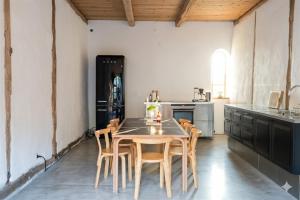 a kitchen with a wooden table and chairs at Gladeholm - Kivik - artist studio in Kivik