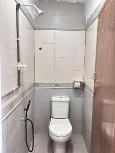 a small bathroom with a toilet and a shower at Arkan Motel Transit in Kampung Kuala Besut