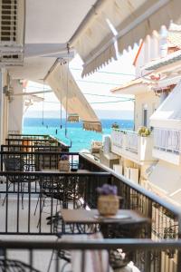 a balcony with tables and chairs and the ocean at Six Doors in Pefkochori