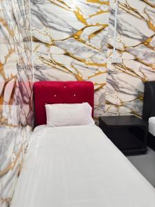 a bedroom with a white bed and a stone wall at Arkan Motel Transit in Kampung Kuala Besut