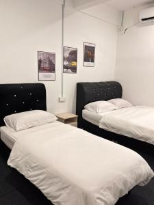 two beds in a room with two beds sidx sidx sidx sidx at Arkan Motel Transit in Kampung Kuala Besut