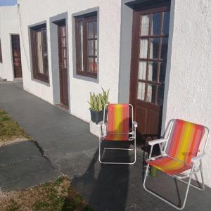 two chairs are sitting outside of a building at Paraíso Chuí in Santa Vitória do Palmar