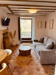 a living room with a couch and a table at Gites Lisael et le 1808 proches Puy DuFou in Mauléon