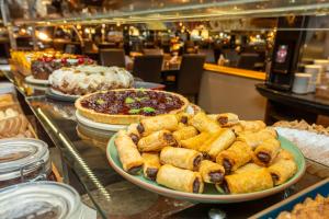 a buffet filled with different types of food on a table at Slaviero Hotel Curitiba Centro in Curitiba +90 photos