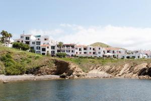 a group of houses on a hill next to the water at Comitas Tramontana Park in Fornells