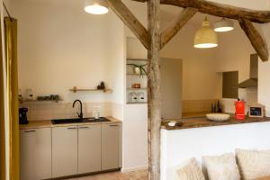 a kitchen with white cabinets and a counter top at Gites Lisael et le 1808 proches Puy DuFou in Mauléon