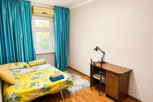 a bedroom with a bed and a desk with a lamp at Large Appartment & Central Place in Tashkent +6 photos