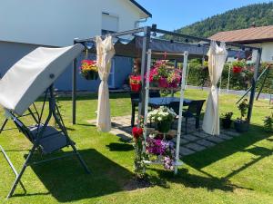 a gazebo with flowers and a table at Cozy ground floor apartment in Xonrupt-Longemer