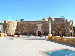 a building with a stone wall and a courtyard at La LLar in Carboneras +23 photos