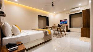 a hotel room with a bed and a dining room at The Sapphire Hotel in Belgaum