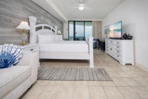 a bedroom with a bed and a tv and a couch at Phoenix IX 1105 condo in Orange Beach