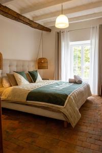 a bedroom with a large bed and a window at Gites Lisael et le 1808 proches Puy DuFou in Mauléon