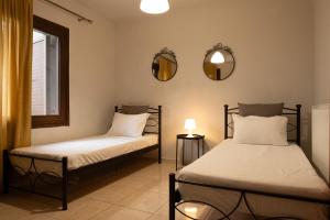 zwei Betten in einem Zimmer mit Spiegel und Fenster in der Unterkunft Marlen Luxury Studios & Apartments in Platamonas