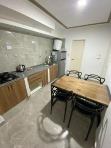 a kitchen with a wooden table and two chairs at Lorenzo Suites Hotel in San Miguel de Tucumán
