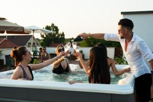 a group of people drinking wine in a hot tub at Majestic Boutique Hotel ADULT ONLY in Baile Felix