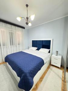 a bedroom with a large bed with a blue comforter at Guest House Darka in Bijela