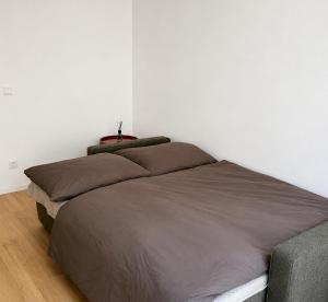 a bed in a bedroom with a white wall at Studio 202 in Brno