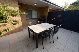 a wooden table and chairs on a patio at Apartments by Townhouse in Wagga Wagga