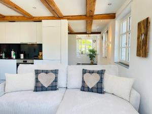 a white couch with heart pillows on it in a kitchen at Appartement "Loft Seeliebe" in Kreuzlingen