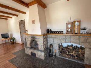 a stone fireplace in a living room with a clock at Pension V Doubí apartmán se sdílenou koupelnou in Slavče