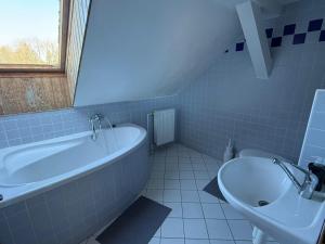 a bathroom with a bath tub and a sink at Pension V Doubí apartmán se sdílenou koupelnou in Slavče +15 photos