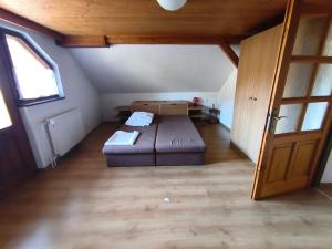 a room with a bed and a couch in a attic at Pension V Doubí apartmán se sdílenou koupelnou in Slavče