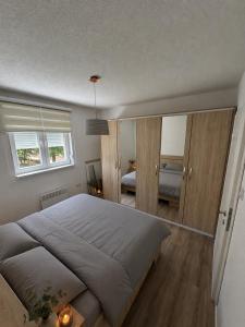 a bedroom with a large bed and a mirror at Apartment Harmony Sarajevo Vogošća in Vogošća