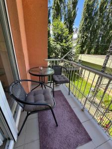 a patio with a table and chairs on a balcony at Apartment Harmony Sarajevo Vogošća in Vogošća