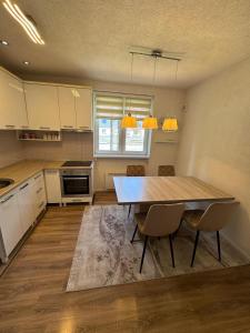 a kitchen with a wooden table and chairs in it at Apartment Harmony Sarajevo Vogošća in Vogošća