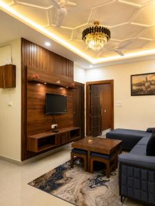 a living room with a couch and a tv at The Elite Luxury Suite in Dehradun