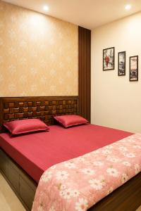 a bedroom with a large bed with red sheets at The Elite Luxury Suite in Dehradun