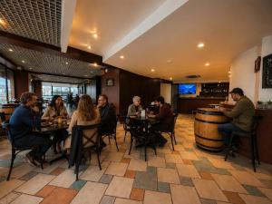 a group of people sitting at tables in a restaurant at LRH Viña del Mar and Convention Center - Ex Gala Hotel in Viña del Mar