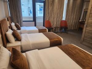 a hotel room with two beds and a window at Qorqud Hotel - Free Massage in Baku