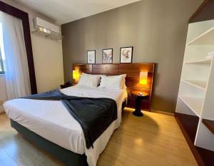 a bedroom with a large bed and a book shelf at Studio apartment in downtown Joinville, SC in Joinville