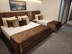 two beds sitting in a hotel room with at Qorqud Hotel - Free Massage in Baku
