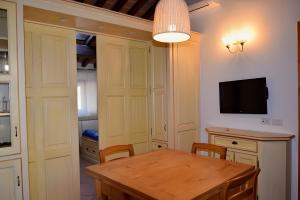 a dining room with a table and a tv at Il Cantinone A due passi dal mare in San Vincenzo +8 photos