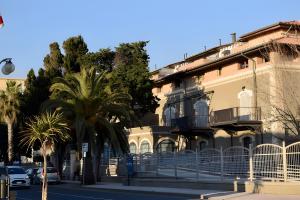 a building with palm trees in front of a street at Il Cantinone A due passi dal mare in San Vincenzo