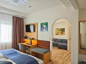 a hotel room with a bed and a desk at Wellness Hotel Garni Krone in Baiersbronn