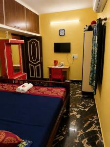 a room with a bed and a table and a refrigerator at La Baie Homestay in Pondicherry