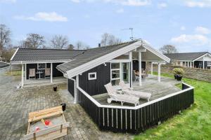 a black house with two chairs on a deck at 30101-Malling-Noddevaenget-5-A in Malling