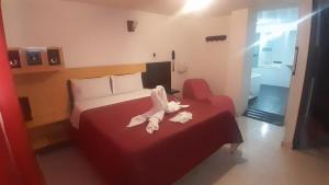 a hotel room with a bed with a stuffed animal on it at Hotel Bonaire Un Estilo Difrente in Bogotá
