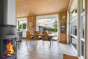 a dining room with a table and a fireplace at C11333-Tarm-Laksestien-6 in Tarm