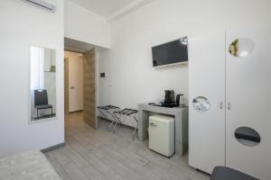 a white room with a kitchen and a table at SpeziAMo Rooms in La Spezia